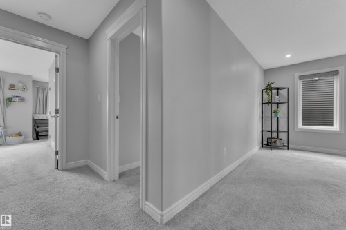 Carpeted hallway with light gray walls, white trim, and recessed lighting - 17551 64 Street, Edmonton, AB 