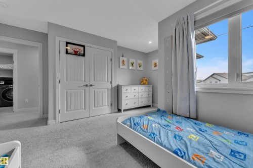 Carpeted room with a large window, a pair of paneled double doors, and recessed lighting - 17551 64 Street, Edmonton, AB 