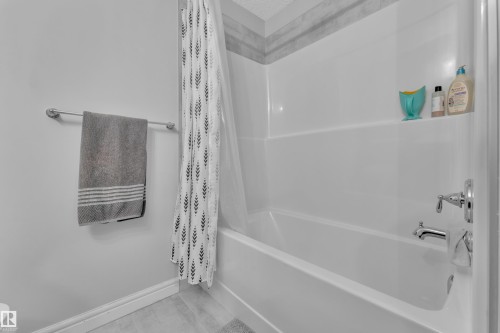 White bathtub with chrome fixtures and integrated shelving - 17551 64 Street, Edmonton, AB 