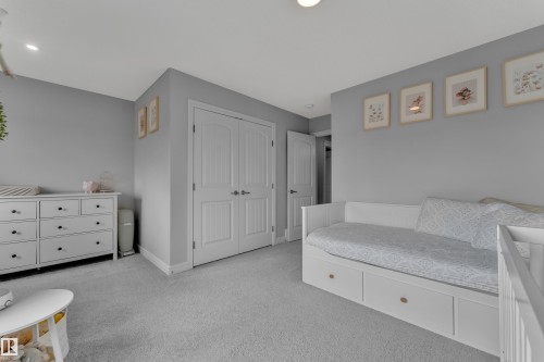 Spacious room featuring neutral gray walls, plush carpeting, a double-door closet with paneling, recessed lighting, and white baseboards - 17551 64 Street, Edmonton, AB 