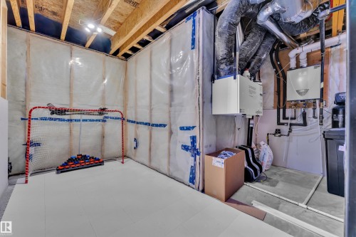 Unfinished basement space featuring exposed wood joists and ceiling-mounted lighting - 17551 64 Street, Edmonton, AB 