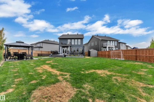 Spacious backyard featuring an extensive lawn area, a large patio with a gazebo, and a storage shed - 17551 64 Street, Edmonton, AB 