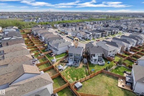 Rear exterior featuring a multi-level deck, fenced yard with green space, and a storage shed - 17551 64 Street, Edmonton, AB 