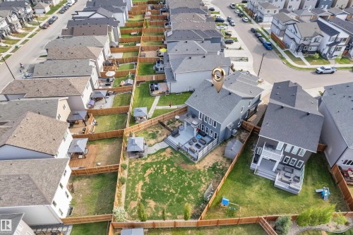 Fenced backyard featuring a spacious composite deck, an expansive lawn, and a gravel pathway - 17551 64 Street, Edmonton, AB 