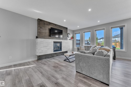 Living area featuring a floor-to-ceiling fireplace with a dark tiled surround and a light-toned hearth - 17551 64 Street, Edmonton, AB 