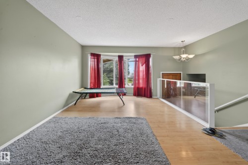 Open-concept living area featuring light wood-finish flooring and a bay window - 2832 35 Street, Edmonton, AB 