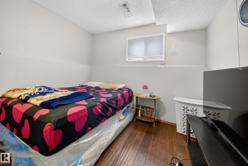 Room featuring wood-finish flooring, a window with blinds, and white walls - 2832 35 Street, Edmonton, AB 