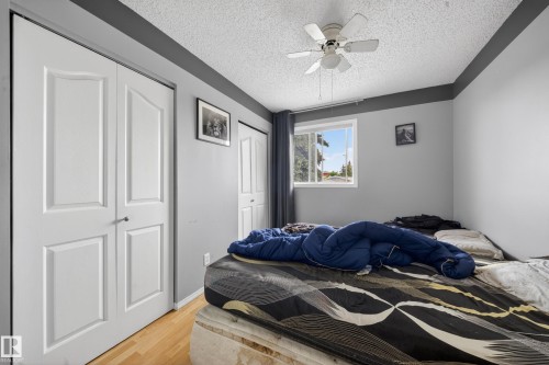 Bedroom featuring light wood-finish flooring, a white ceiling fan, and a window with white trim - 2832 35 Street, Edmonton, AB 