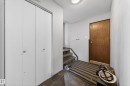 Foyer featuring slate tile flooring, wood-finish interior door, textured ceiling, and bi-fold closet doors - 2832 35 Street, Edmonton, AB 