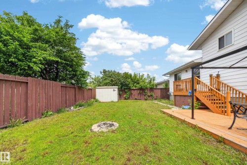 Expansive backyard featuring a wood deck with stairs, a built-in fire pit, a storage shed, and a privacy fence - 2832 35 Street, Edmonton, AB 