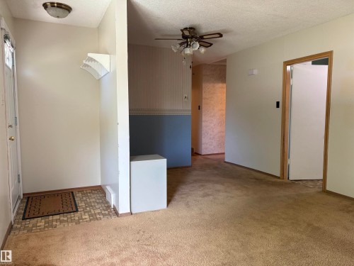 Entryway with patterned tile flooring and a white paneled door - 5511 50 St, Tofield, AB 