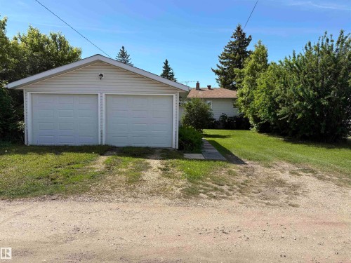 Detached two-car garage with white panel doors and vinyl siding - 5511 50 St, Tofield, AB 