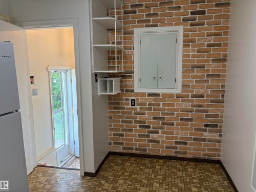 Brick-patterned wall feature with a built-in cabinet - 5511 50 St, Tofield, AB 