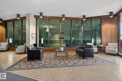 Lounge area featuring patterned carpeting, tile flooring, and wood-paneled walls - 
