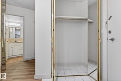Mirrored bi-fold closet doors with gold-toned trim and white tile flooring - 