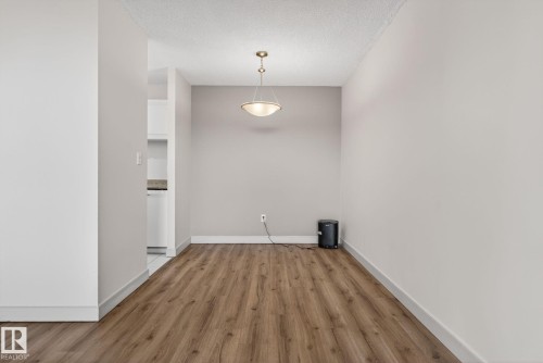 Dining area featuring wood-finish flooring and a contemporary ceiling light fixture - 412 13910 Stony Plain Road, Edmonton, AB 