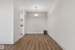 Dining area featuring wood-finish flooring and a contemporary ceiling light fixture - 
