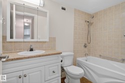 Bathroom featuring a white vanity with a light-colored countertop, an integrated sink, and a mirrored medicine cabinet - 