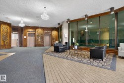 Lobby featuring wood-paneled walls with carved accents, two elevators, and a tiled floor - 