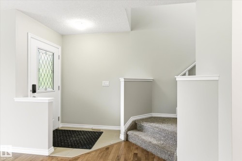 Entryway featuring a white door with leaded glass, light neutral wall paint, and white trim - 9039 219 Street, Edmonton, AB 