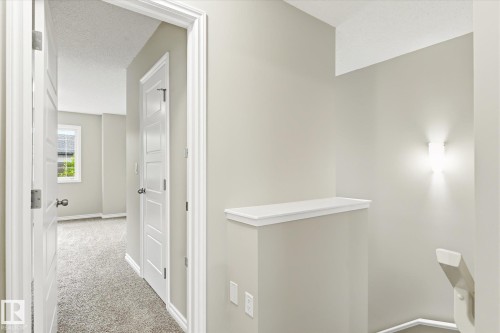 Neutral-toned interior hall with carpeted flooring - 9039 219 Street, Edmonton, AB 
