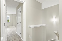 Neutral-toned interior hall with carpeted flooring - 