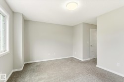 Room featuring light gray wall paint, gray carpet flooring, white baseboards, and a white ceiling with a flush-mount light fixture - 