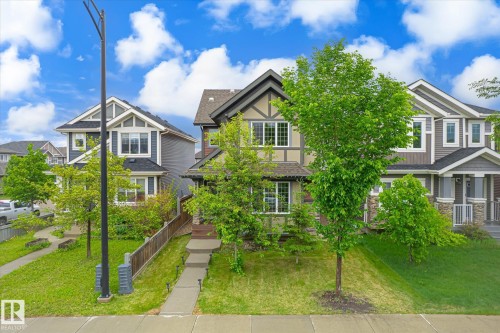 Two-story detached residence featuring a blend of exterior finishes, including siding, stone accents, and stucco with timber detailing - 9039 219 Street, Edmonton, AB 