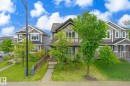 Two-story detached residence featuring a blend of exterior finishes, including siding, stone accents, and stucco with timber detailing - 9039 219 Street, Edmonton, AB 