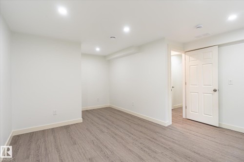 Room featuring wood-finish flooring, recessed lighting, white walls, and white trim - 9039 219 Street, Edmonton, AB 