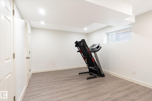 Finished room featuring wood-finish flooring, recessed lighting, and a window - 9039 219 Street, Edmonton, AB 