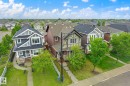 Residential street featuring a variety of distinct architectural styles, including a prominent blue home with stone facade accents and a gabled roof - 9039 219 Street, Edmonton, AB 