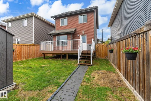 Expansive rear yard featuring a wood-finish fence, a paver stone pathway, and a detached storage shed - 9039 219 Street, Edmonton, AB 