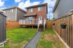 Expansive rear yard featuring a wood-finish fence, a paver stone pathway, and a detached storage shed - 