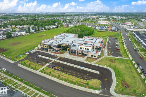 Contemporary commercial building featuring a multi-level roofline, extensive paved parking, and surrounding green spaces - 9039 219 Street, Edmonton, AB 