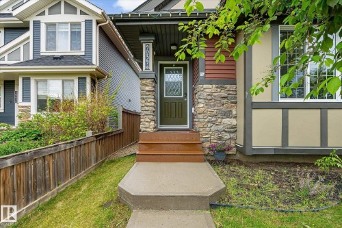 Stone veneer and horizontal siding facade with a dark green entry door - 9039 219 Street, Edmonton, AB 