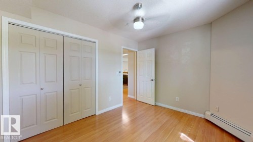 Light wood-finish flooring complements the neutral wall tones - 201 11408 108 Avenue, Edmonton, AB 