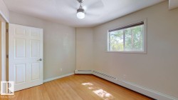 Room featuring light wood-finish flooring, a white six-panel door, and a single window with a white frame - 