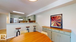 Kitchen with light-colored cabinetry, stainless steel appliances, and a breakfast bar - 