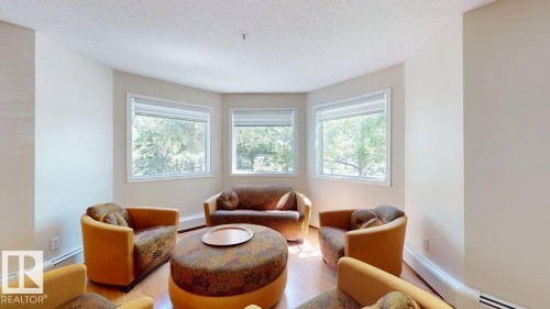 Bay window with three large windows, white trim, and white blinds - 201 11408 108 Avenue, Edmonton, AB 