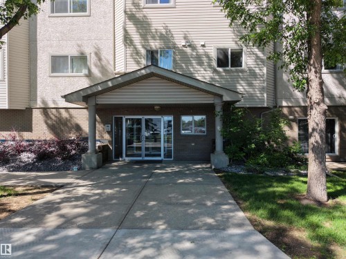 Building entrance featuring a covered porch with supporting columns and double glass doors - 201 11408 108 Avenue, Edmonton, AB 