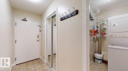 Entryway featuring tile flooring, a mirrored closet with sliding doors, and a coat rack - 