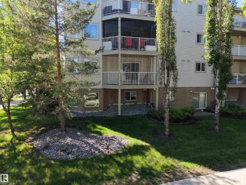 Multi-story building featuring light-colored siding and a brick-finish lower level - 201 11408 108 Avenue, Edmonton, AB 