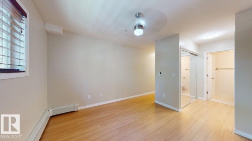 Light wood-finish flooring complements neutral wall tones - 201 11408 108 Avenue, Edmonton, AB 