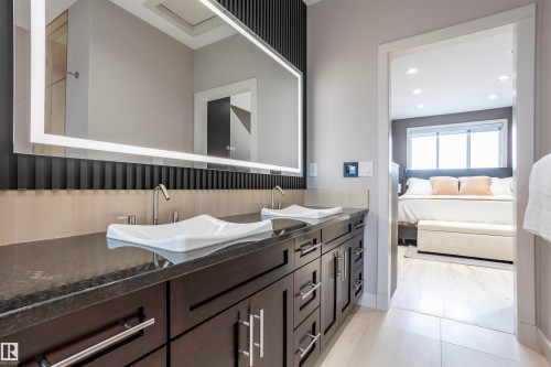 Spacious bathroom featuring a dual vanity with rectangular vessel sinks, dark wood cabinetry, and a stone countertop - 4949 Terwillegar Common, Edmonton, AB 