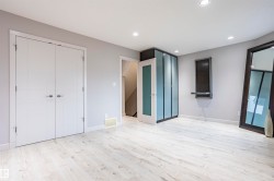 Spacious room featuring light wood-finish flooring, recessed ceiling lighting, and a neutral wall color - 