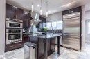 Gourmet kitchen with dark wood cabinetry, stainless steel appliances, granite countertops, and a central island - 4949 Terwillegar Common, Edmonton, AB 