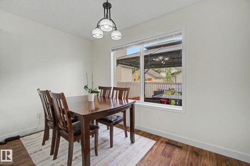 Bright interior space with wood-finish flooring and white baseboards - 710 Glenwright Court, Edmonton, AB 