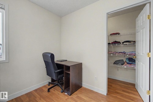 Room featuring wood-finish flooring, light-colored walls, and a window with white trim - 710 Glenwright Court, Edmonton, AB 