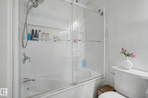 Bathtub with sliding glass enclosure and integrated shower niche - 710 Glenwright Court, Edmonton, AB 